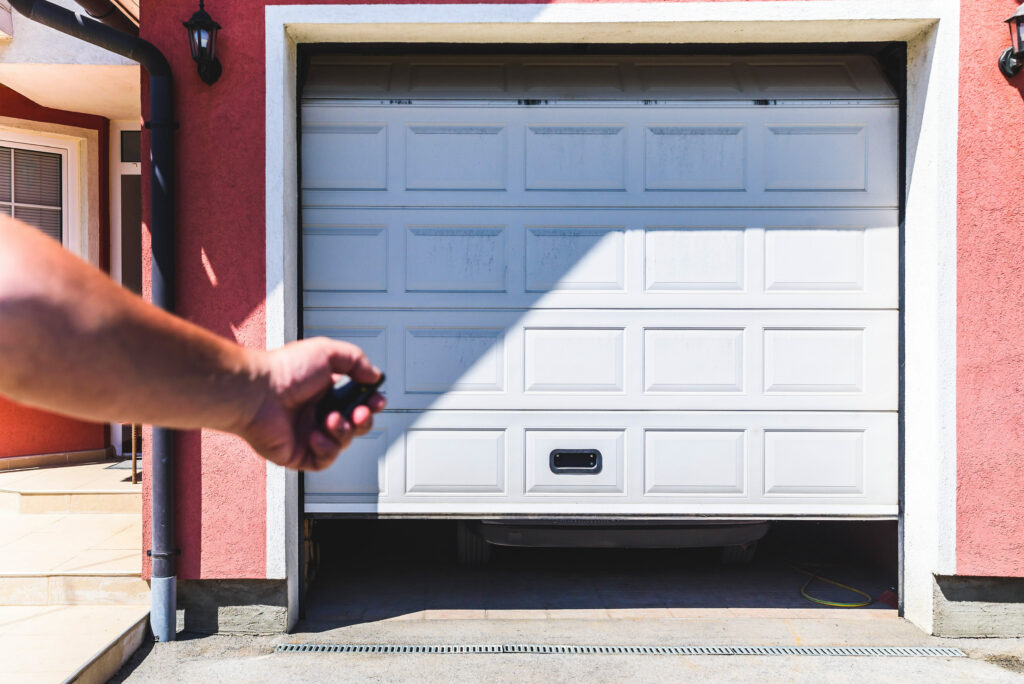 La porte d'un garage s'ouvre à distance à l'aide d'une télécommande électrique.