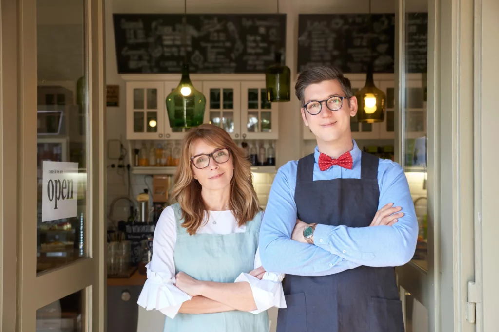 Deux commerçants se tenant sur le pas de la porte d'un local commercial, illustrant le constat de l'état des lieux de l'espace commercial