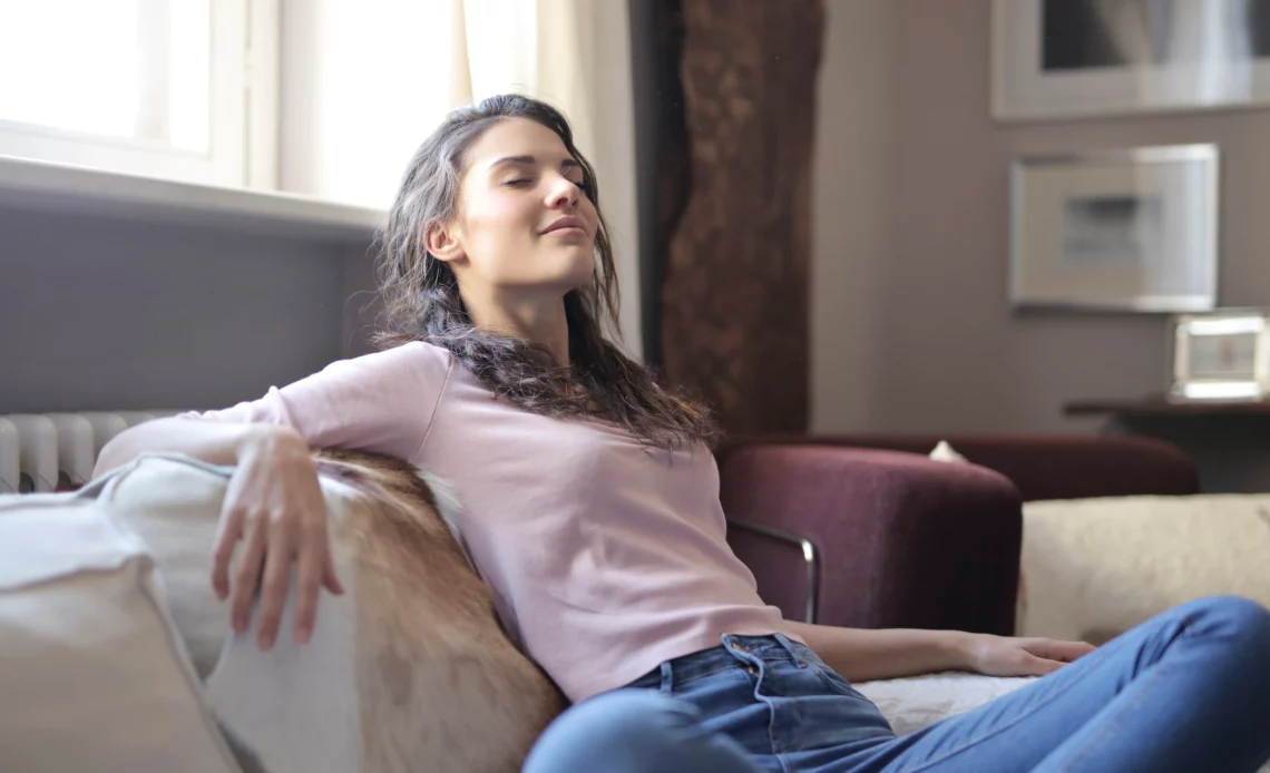 Femme se reposant sur un canapé pour illustrer le repos ou l'absence de bruit le dimanche