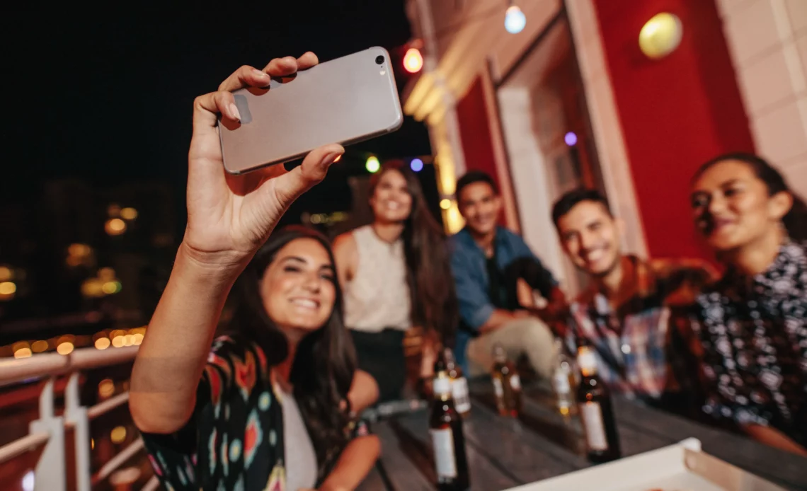 Groupe d'amis en train de faire la fête sur une terrasse d'immeuble pour illustrer un tapage nocturne le samedi soir